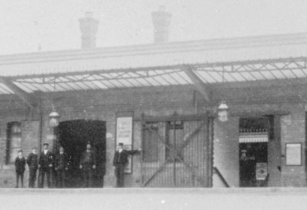 Close up showing the entrance to the underpass to the up platform and some of Warwick station's staff posed for the camera