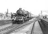 GWR 4-6-0 King class No 6026 'King John' with just a slight evidence of smoke at the chimney roars through the station on a down express service