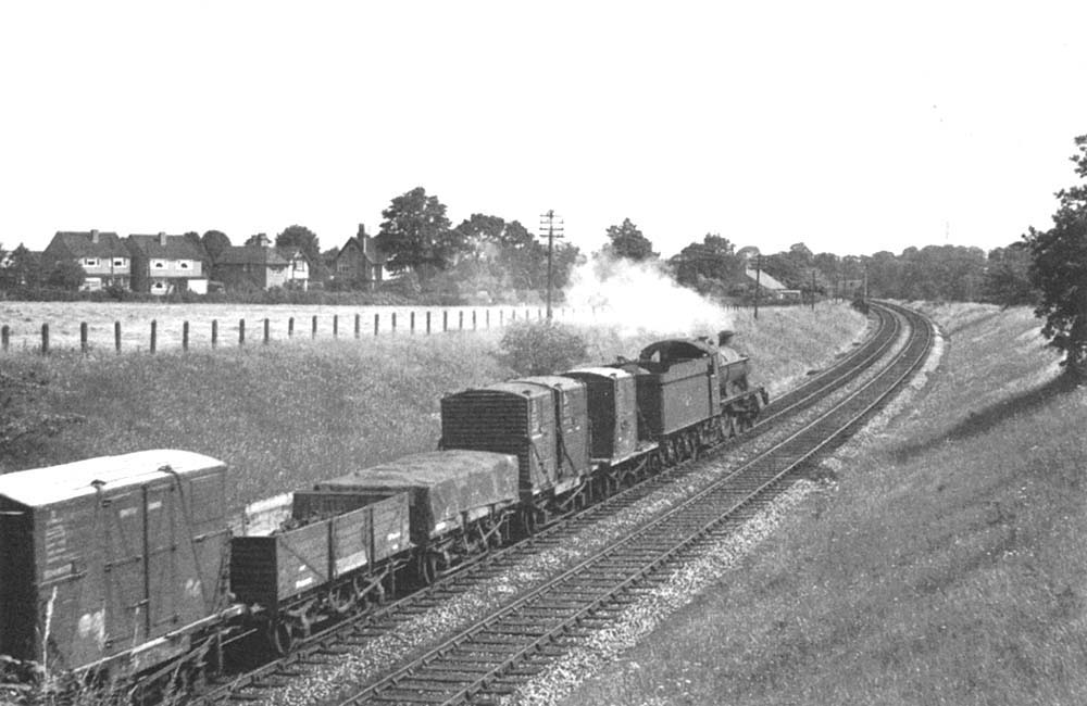 Another view of ex-GWR 4-6-0 Hall class No 4905 'Barton Hall as it moves away from the Halt at the head of an up Class D express freight service on 8th July 1962