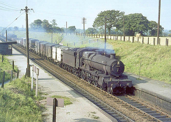 Ex-GWR 4-6-0 Grange class No 6870 'Bodicote Grange' is seen passing through Whitlocks End Halt on an up freight service on 30th August 1964