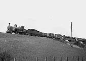 GWR 0-6-0 Dean Goods No 2325 is seen on an embankment near the station at the head of an up goods train