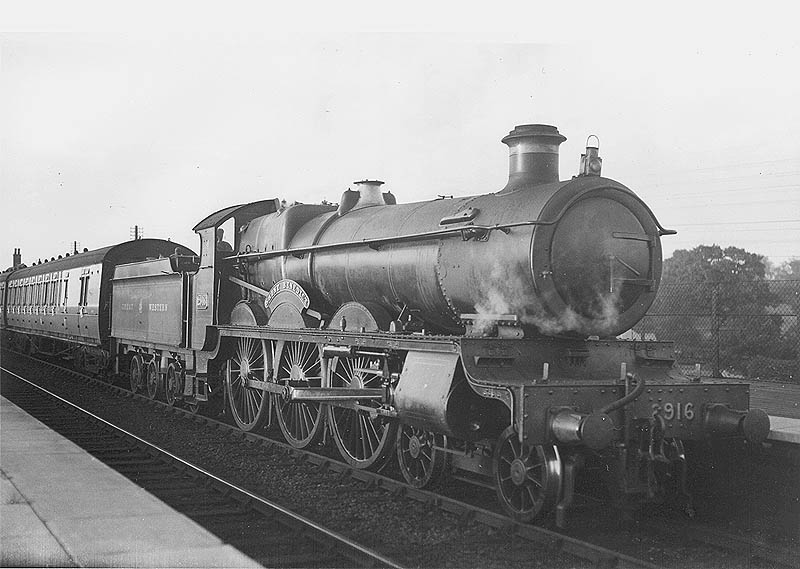 GWR 4-6-0 Saint class No 2916 'Saint Benedict' is seen with the former eight-wheeled 'Great Bear' tender at the head of an up local passenger train