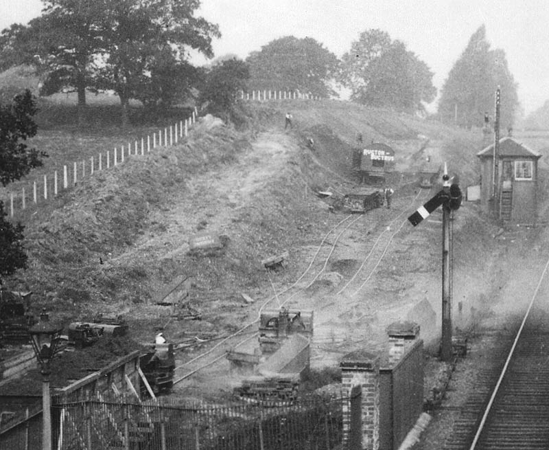 Close up showing the contractors at work including the Ruston Bucyrus crane being used to dig the earth and the temporary track