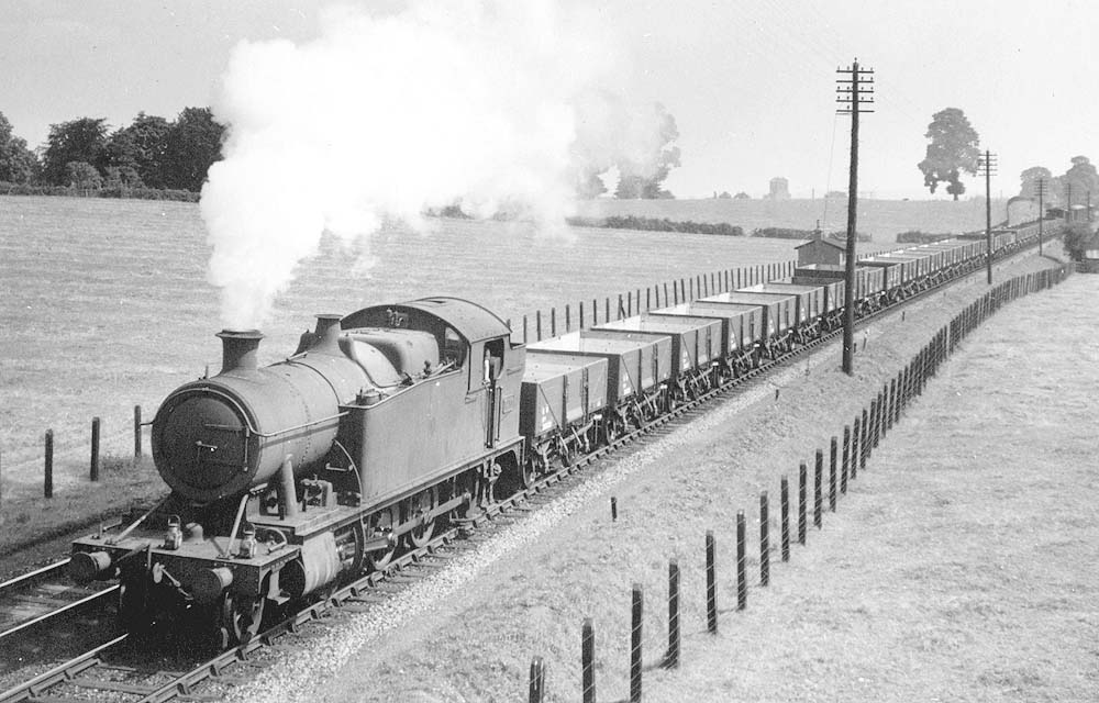 GWR 2-8-0T 5205 class No 5233 is seen at the head of a train of brand new mainly 12 ton five-plank wagons as it climbs Wilmcote Bank on 4th August 1940