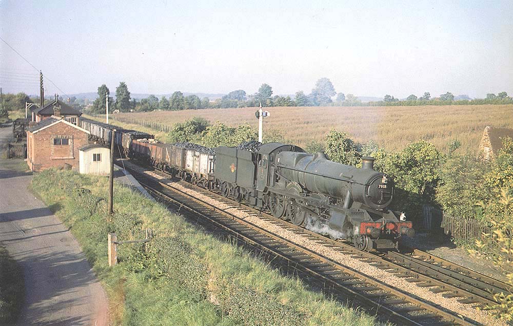 British Railways built 4-6-0 Modified Hall class No 7918 'Rhose Wood Hall' passes the original Wilmcote station whilst at the head of a down mineral train