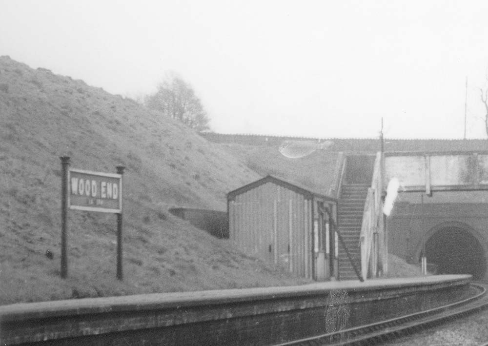 Close up showing the simple GWR standard corrugated asbestos passenger waiting room design located at the bottom of the footbridge steps on the down platform