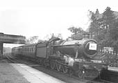 GWR 4-6-0 Hall class No 5930 'Hanngton Hall' is seen passing through the station at speed whilst at the head of a down West Country excursion train
