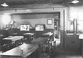 View inside Aston shed's staff canteen with serving staff visible through the two serving hatches on the back wall