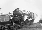 Ex-LMS 5MT 4-6-0 No 44935 is seen on a foggy and wet day departing the West end of Platform 6 on the 9 50am stopping train to Manchester London Road