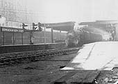 An unidentified ex-LMS 4-6-0 'Black 5', considered one of the finest mixed traffic locomotives in the country, is seen at the head of a three-coach local stopping train