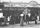 Passengers mill around the locked gates of Station Street during the 1911 railway strike