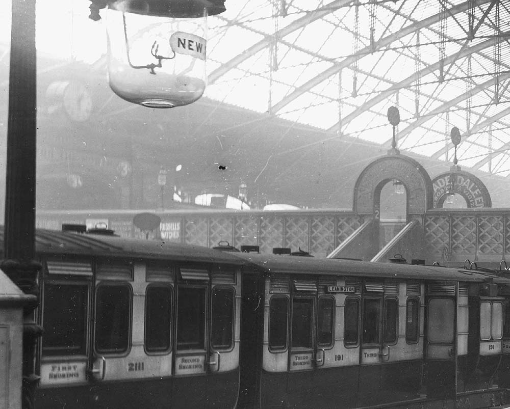 Close up of Platform One with a local train standing at the platform with one of the carriages carrying a 'Leamington' destination board