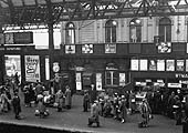 View of a very busy Platform 7 seen from the passenger footbridge looking towards Queens Drive showing the building which initially housed offices for Midland Railway staff
