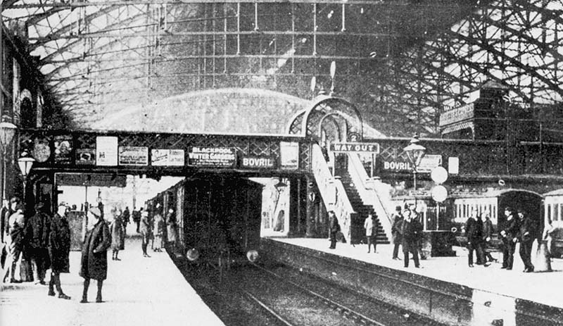 Looking towards Wolverhampton along New Street station's Platform 3 with on the right train indicator boards and clocks standing on Platform 2