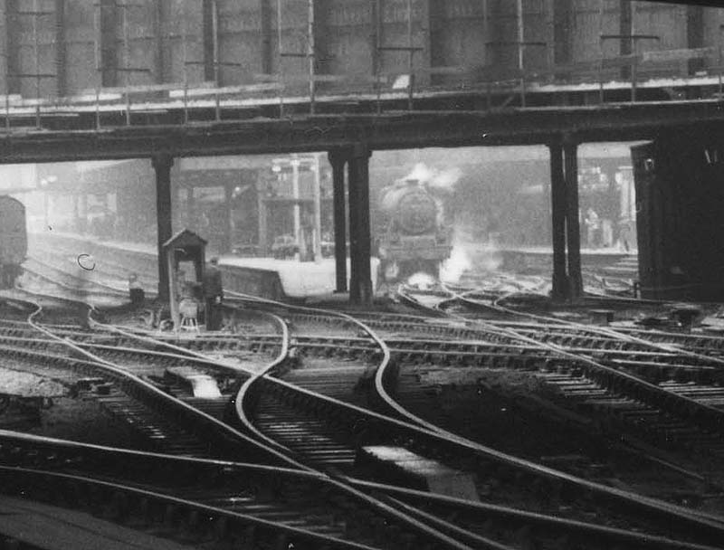 Close up looking under the bridge showing an unidentified ex-LMS 4-6-0 'Stanier Black 5' standing at Platform 4 with a down express service to Wolverhampton