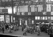 View of a very busy Platform 7 seen from the passenger footbridge looking towards Queens Drive showing the building which initially housed offices for Midland Railway staff