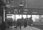 Close up with two unidentified Midland locomotives standing on the centre road and the cantilevered LNWR signal over the platform