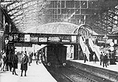 Looking towards Wolverhampton along New Street station's Platform 3 with on the right train indicator boards and clocks standing on Platform 2