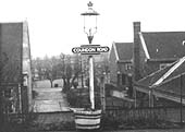 A gas lit lamppost on Coundon Road station's up platform displaying a British Railway's 'totem' station sign erected in 1954