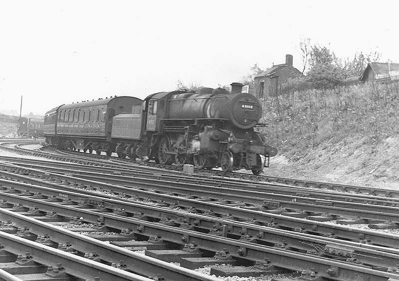 Ex-LMS 4MT 2-6-0 Mogul No 43002 draws coaching stock from the carriage sidings that lay opposite the shed into the down platform