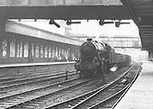 Ex-LMS 8F 2-8-0 No 48449 is seen running through Coventry station on the through road at the head of a train of mineral wagons