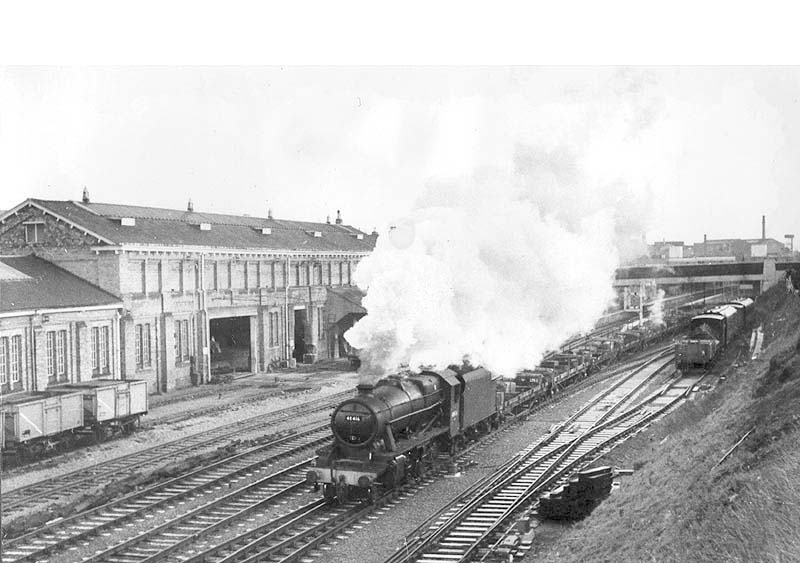 Ex-LMS 2-8-0 8F No 48416 is seen heading north under Warwick Road bridge with an empty engineering train of trucks for carrying rails