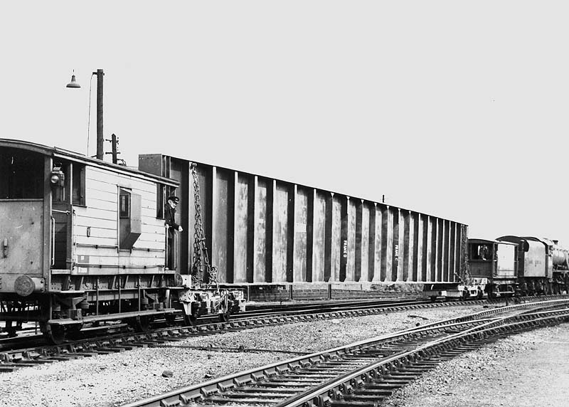 View of the special load being carried on a pair of bogies sandwiched between two LMS brake vans behind ex-LMS 2-8-0 8F No 48716