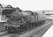 Ex-LMS 3MT 2-6-2T No 40135 is seen standing at rest on the truncated down through road in between moving luggage and parcels