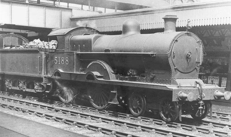 Ex-LNWR 4-4-0 3P Precursor class No 5188 'Marquis' is seen at the head of an up express service passing under the passenger footbridge