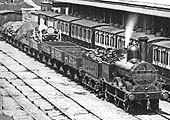 Close up showing a LNWR 0-6-0 DX goods engine on a short train passing the Coventry station on an up goods working
