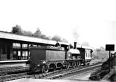 An unidentified LNWR Special DX 0-6-0 locomotive is seen coming off the Leamington branch line towing a brake van whilst the fireman sits precariously on the tender