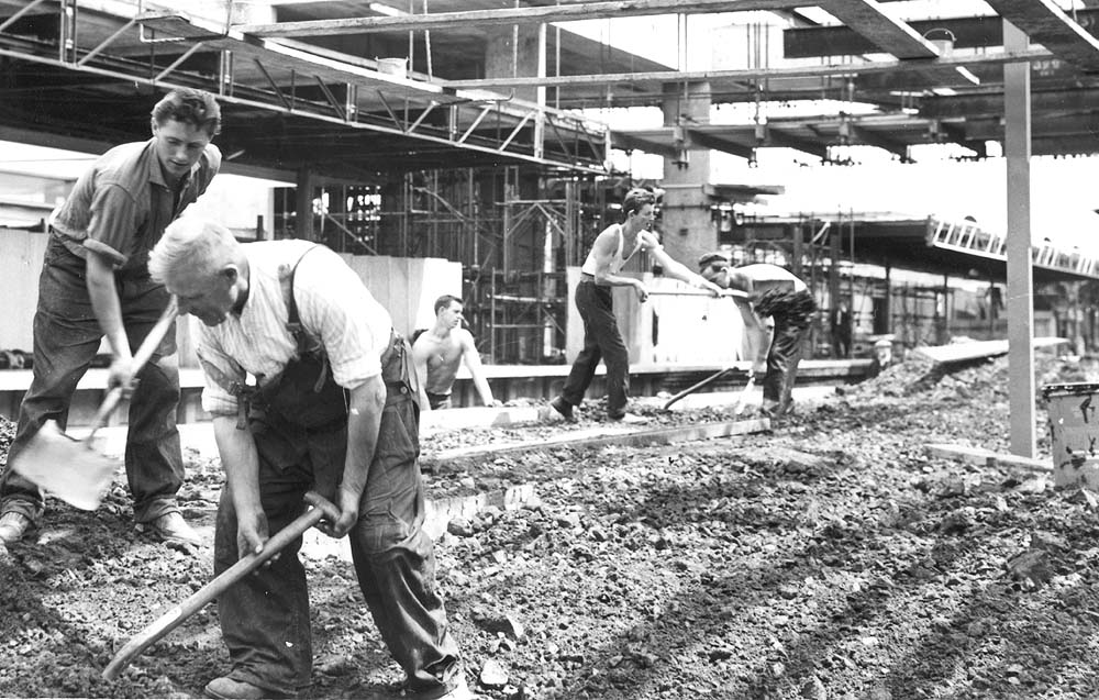 View showing the amount of hand operated work was required during the rebuilding of the station as a gang of labourers completing the backfilling of the island platform