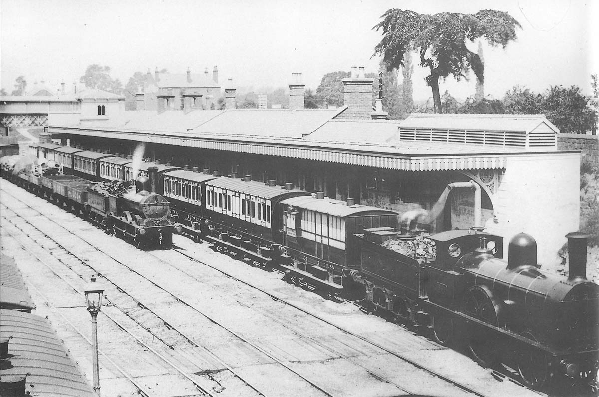 View of Coventry's third station built in 1873 with a LNWR 2-2-2 Bloomer standing at the up platform and a LNWR 0-6-0 DX goods passing through the station