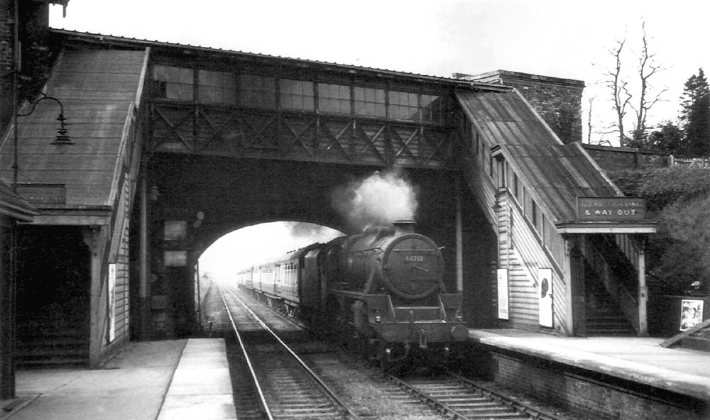 British Railways built 4-6-0 5MT No 44713 passes beneath the road bridge on an up express thought to be the 3:55pm New Street to Peterborough service