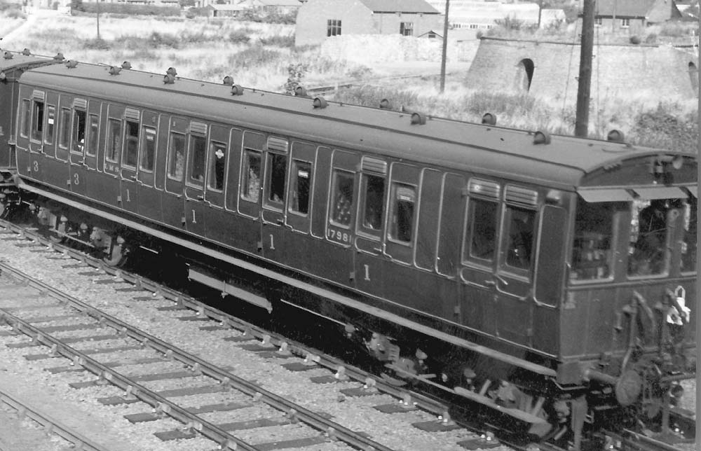 Close up showing the driver standing in the cab and controlling the train via vacuum operated linkages to the locomotive in the centre of the train