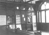 Internal view of the booking hall and panelled facade to the booking clerk's offices with two windows provided for the sale of tickets