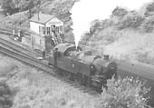 British Railways built Ivatt 2MT 2-6-2T No 41285 is seen running bunker first as it slows down to collect the train staff from the signalman