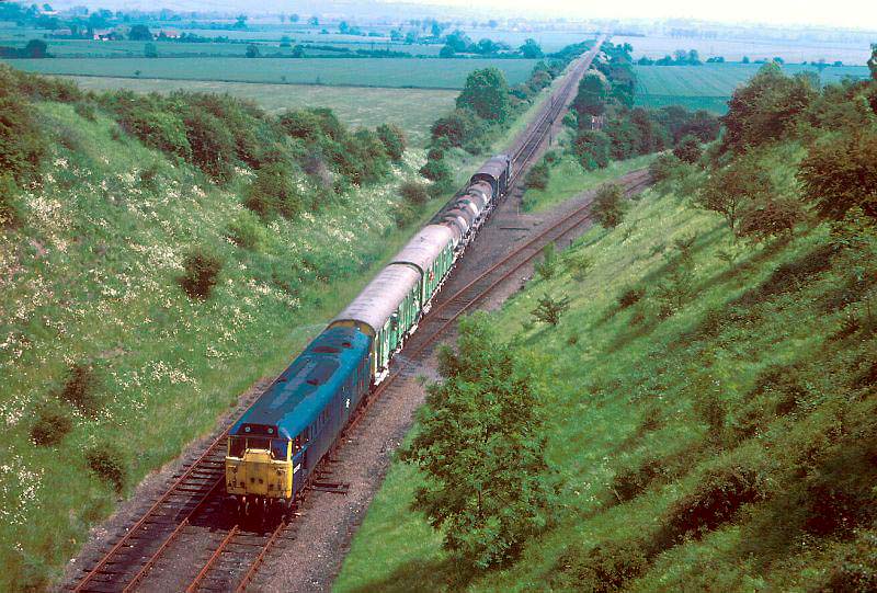 An unknown diesel locomotive at the head of a mixed freight train bound for Southam Cement Works circa early 1980s