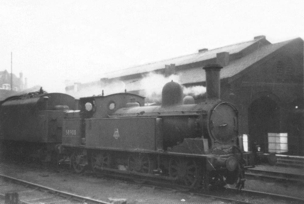 Ex-LNWR 2F 0-6-2T 'Coal Tank' No 58900 is seen on a foggy day stabled alongside the shed
