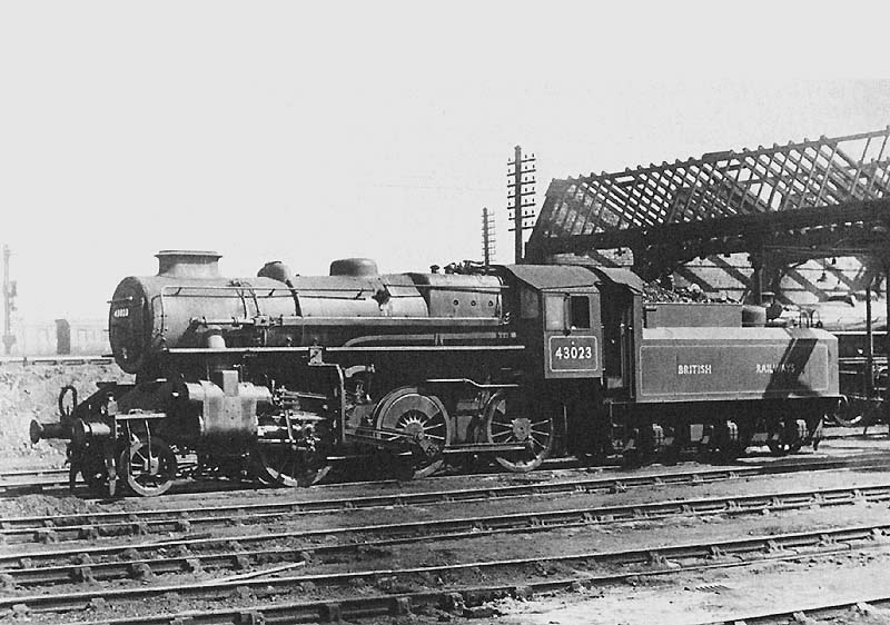 British Railways built Ivatt 4MT 2-6-0 No 43023 is seen standing outside of Nuneaton shed during reconstruction of the shed's roof