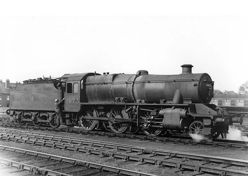 LMS 2-6-0 5MT No 2973 is seen in steam with the driver climbing aboard to move it off shed for its next turn of duty