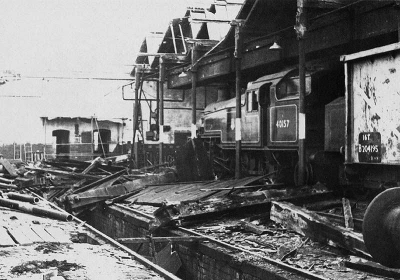 An inside view showing ex-LMS 2-6-2T 3P No 40157 standing in front of an unidentified ex-LMS 2-6-0 during the re-roofing of the shed