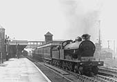 An unidentified ex-LNWR 4-6-0 Prince of Wales class locomotive is seen at the head of a four-coach local stopping service