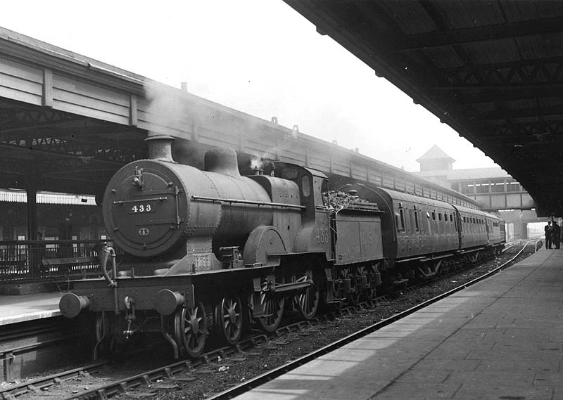 Ex-MR 4-4-0 2P No 433 is seen resting at platform two at the head of a four-coach stopping train from Coventry