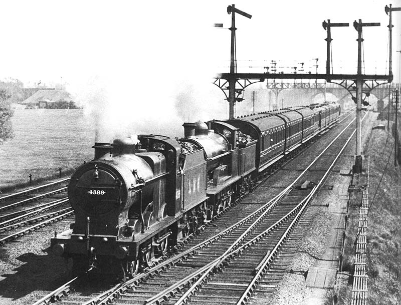 LMS 4F 0-6-0 No 4389 pilots an unidentified ex-LNWR 4-6-0 Prince of Wales class locomotive on a down express as it passes Ashby Junction