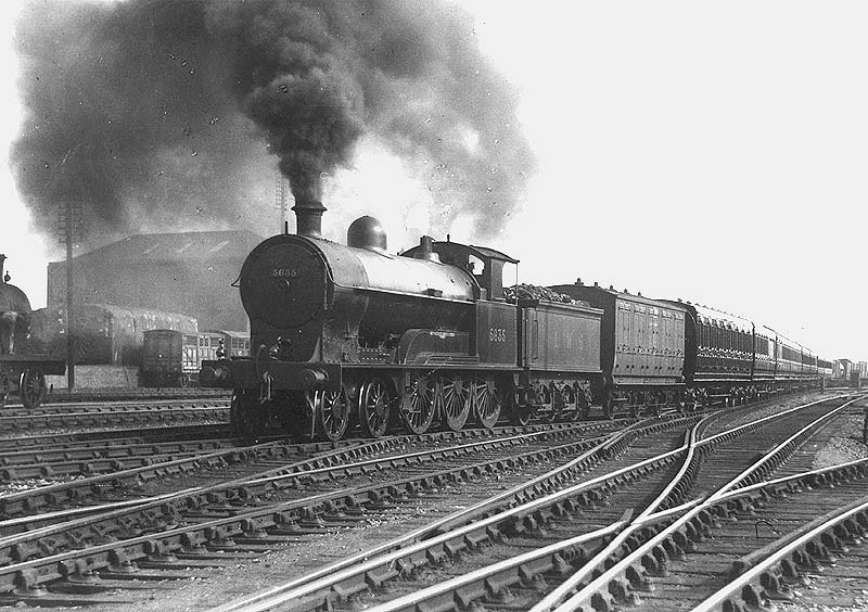 Ex-LNWR 4-6-0 Prince of Wales class No 5635 'Charles Lamb' is seen in red livery approaching Nuneaton station at the head of a down express