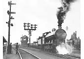 View of an unidentified ex-LNWR 0-8-0 passes Nuneaton's up goods yard signal box as it starts away with a freight working