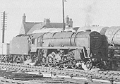 British Railways Standard class 9F No 92009 is seen heading a mineral train out of the marshalling yard as an oil train is being shunted over the  yard's hump