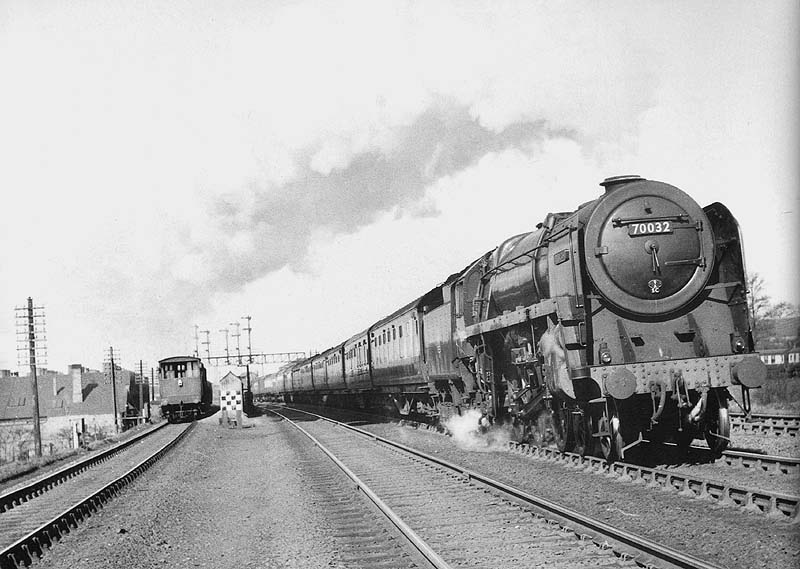 British Railways 4-6-2 Britannia Class No 70032 'Tennyson' is seen passing the carriage sidings on the 8 30am Manchester to Euston express