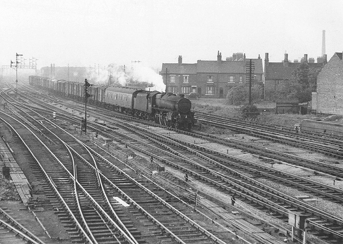 Ex-LMS 4-6-0 5MT No 45089 is seen running at speed on a down fitted freight as it approaches Leicester Road bridge